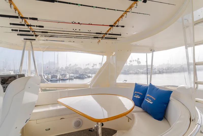 Tribeless Yacht Photos Pics Interior of 2002 Mikelson 70 Sportfisher yacht with fishing rods and seating area.