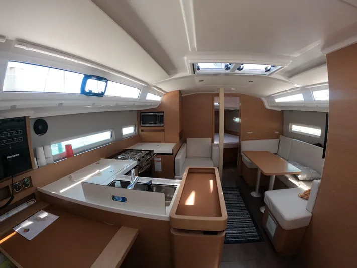 Flyin Yacht Photos Pics Interior of 2020 Jeanneau Sun Odyssey 410 yacht, featuring modern kitchen and seating area.