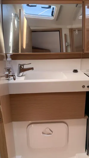 Flyin Yacht Photos Pics 2020 Jeanneau Sun Odyssey 410 bathroom with modern sink and mirror, natural light from skylight.