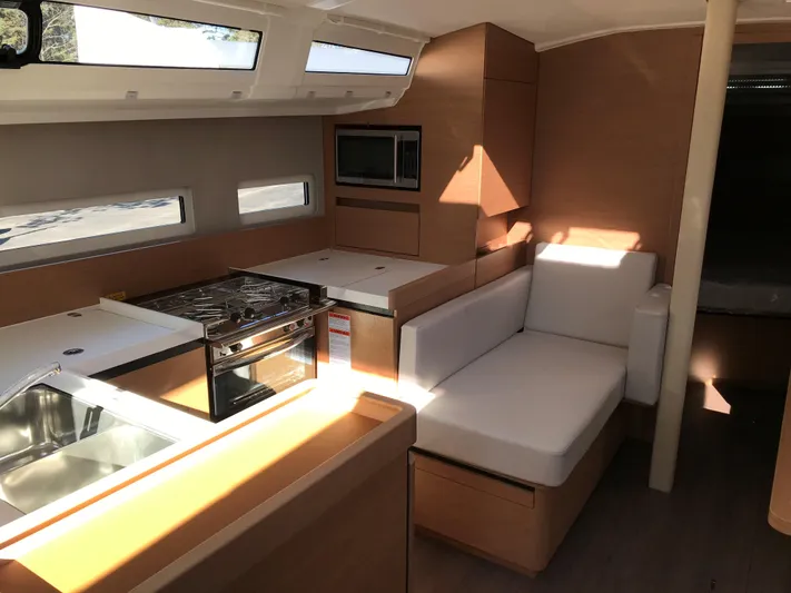 Flyin Yacht Photos Pics Interior of 2020 Jeanneau Sun Odyssey 410 yacht with modern kitchen and seating area.