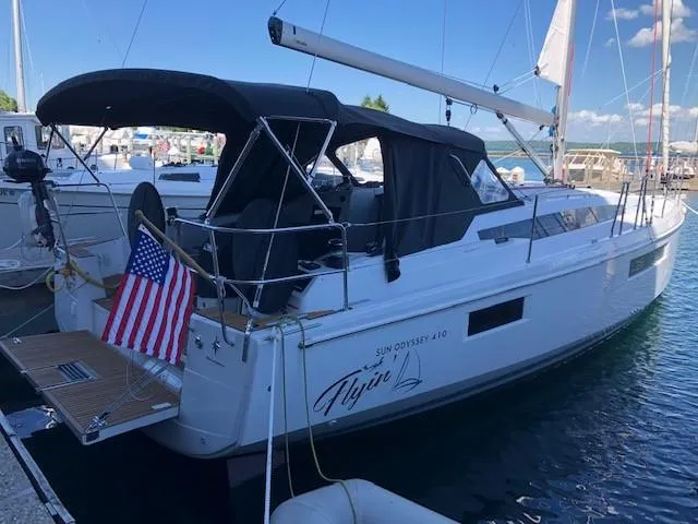 Flyin Yacht Photos Pics 2020 Jeanneau Sun Odyssey 410 sailboat docked, featuring a sleek design and American flag.
