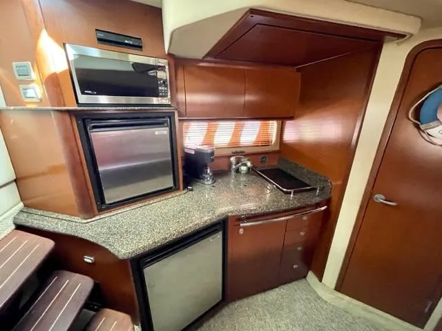 "jimi Thing Iv" Yacht Photos Pics 2007 Sea Ray 38 Sundancer kitchen with microwave, fridge, and wooden cabinetry.