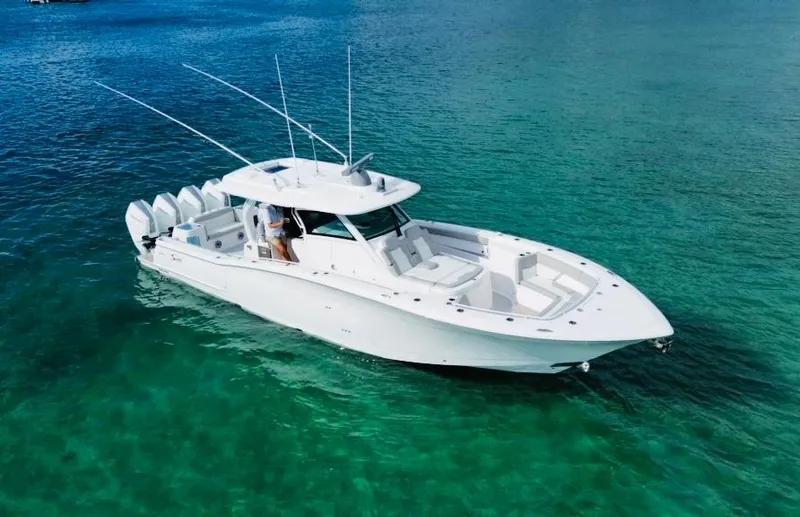  Yacht Photos Pics 2024 Scout 400 LXF boat on clear turquoise water, showcasing sleek design and multiple engines.