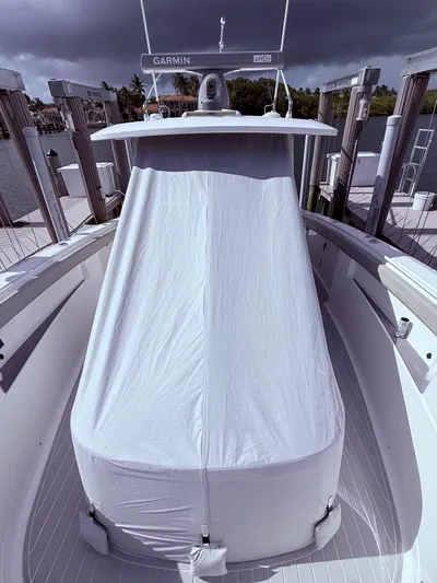  Yacht Photos Pics 2024 Scout 400 LXF boat with covered console, docked under cloudy skies.