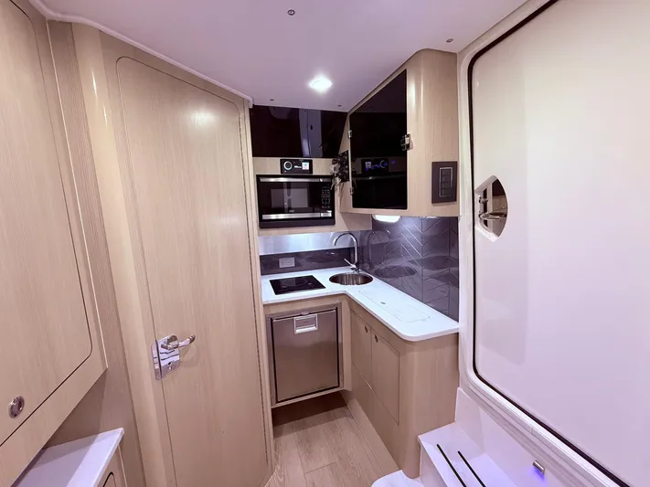  Yacht Photos Pics 2024 Scout 400 LXF boat interior kitchen with modern appliances and sleek design.