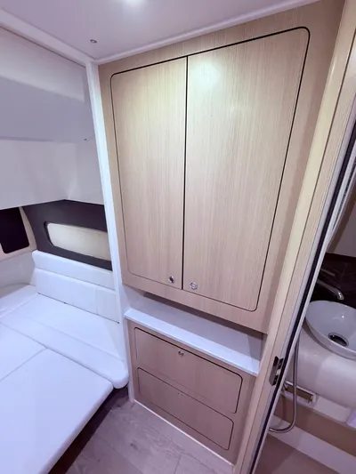  Yacht Photos Pics 2024 Scout 400 LXF cabin interior with wood cabinetry and seating area.
