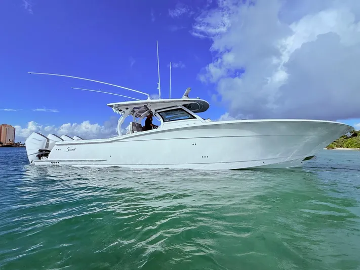  Yacht Photos Pics 2024 Scout 400 LXF boat on clear water under a blue sky.