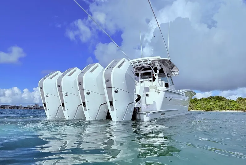  Yacht Photos Pics 2024 Scout 400 LXF boat with multiple engines on water, under a clear blue sky.