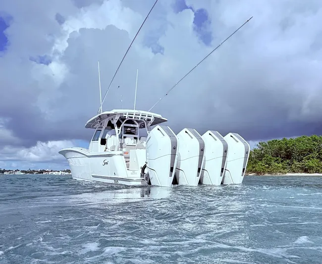  Yacht Photos Pics 2024 Scout 400 LXF boat with multiple engines cruising on water under cloudy skies.