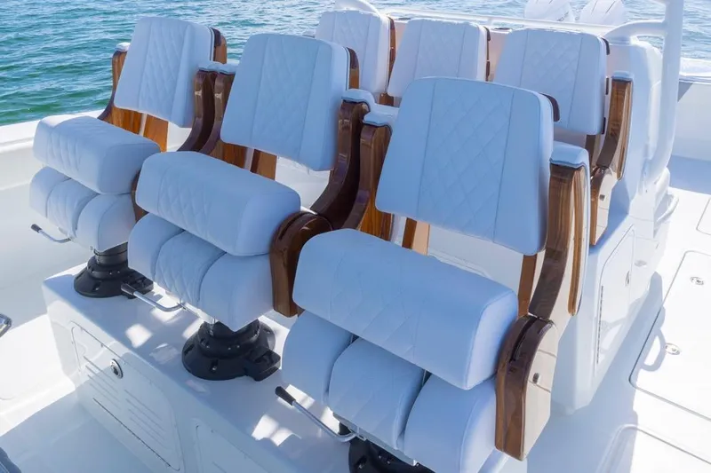  Yacht Photos Pics Luxurious seating on 2026 Invincible 46 Catamaran, featuring white cushioned chairs with wooden accents.