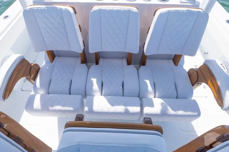  Yacht Photos Pics Luxurious seating on 2026 Invincible 46 Catamaran, featuring quilted white upholstery and wooden accents.
