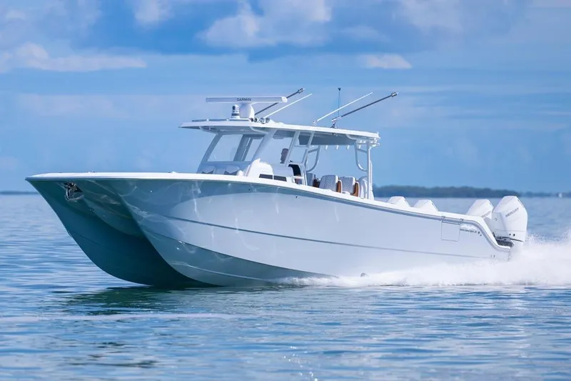  Yacht Photos Pics 2026 Invincible 46 Catamaran cruising on calm waters under a clear blue sky.