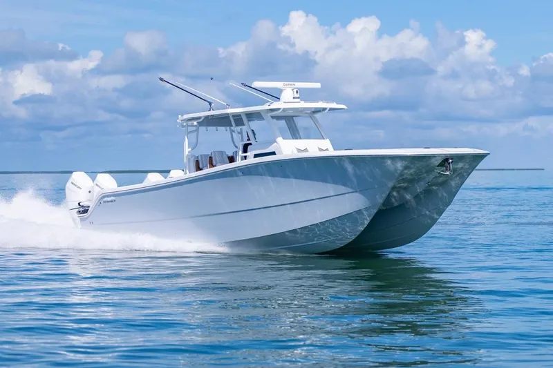  Yacht Photos Pics 2026 Invincible 46 Catamaran cruising on open water under a clear blue sky.