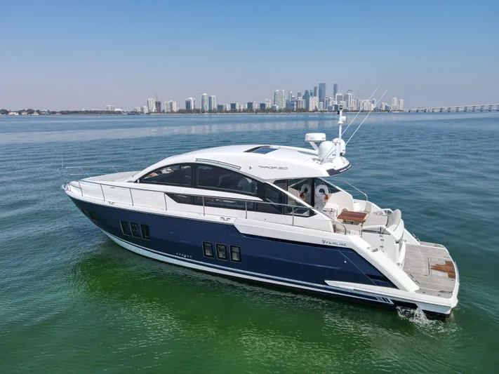  Yacht Photos Pics 2013 Fairline Targa 50 GT yacht cruising on calm waters with city skyline backdrop.