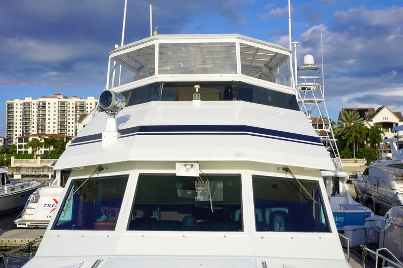 Sunset Grille Yacht Photos Pics 1990 Hatteras 62 Cockpit Motor Yacht docked at marina, with buildings in background.