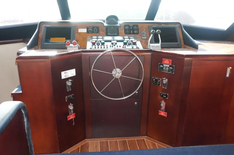 Sunset Grille Yacht Photos Pics Cockpit of 1990 Hatteras 62 Cockpit Motor Yacht with steering wheel and control panels.