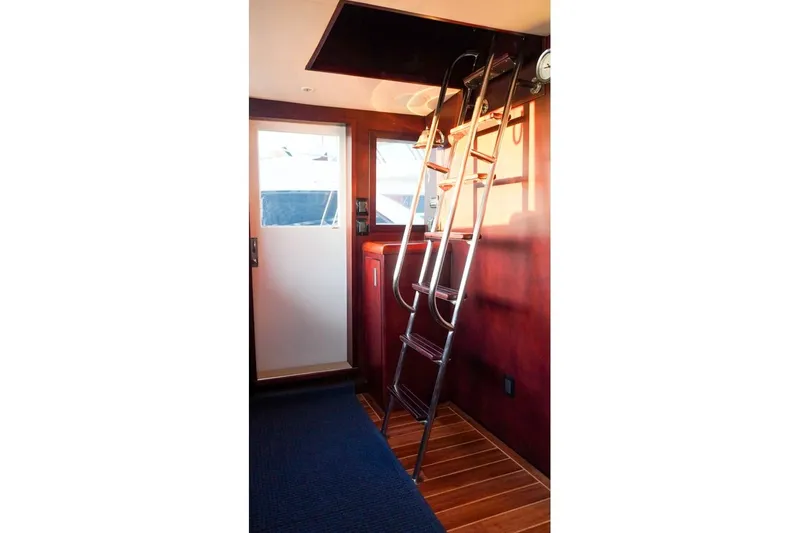 Sunset Grille Yacht Photos Pics Interior of 1990 Hatteras 62 Cockpit Motor Yacht with ladder and wooden flooring.