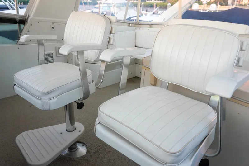 Sunset Grille Yacht Photos Pics White seating area on 1990 Hatteras 62 Cockpit Motor Yacht, featuring plush chairs and elegant design.