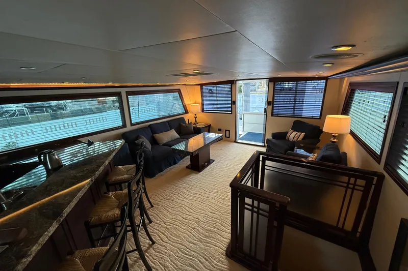 Sunset Grille Yacht Photos Pics Luxurious interior of 1990 Hatteras 62 Cockpit Motor Yacht with elegant seating and large windows.