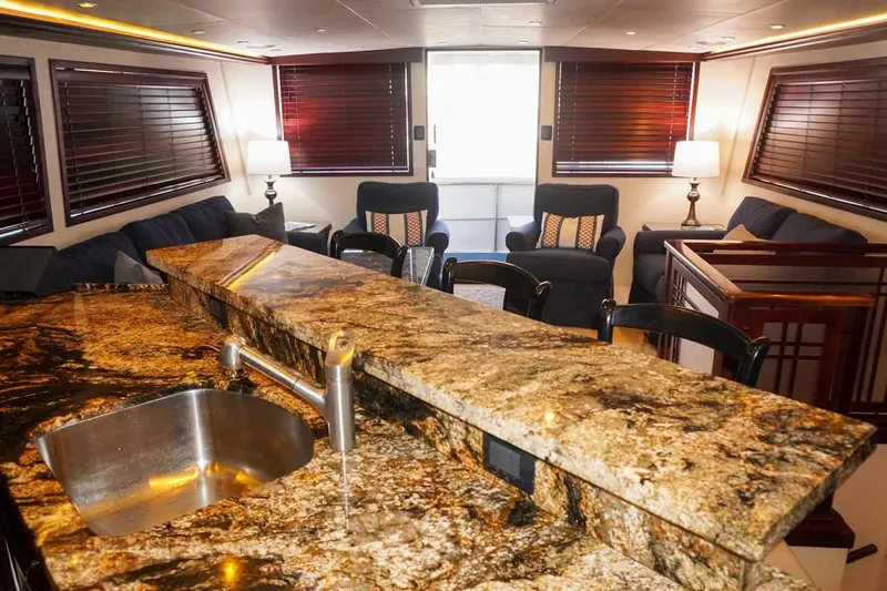 Sunset Grille Yacht Photos Pics Luxurious interior of 1990 Hatteras 62 Cockpit Motor Yacht with granite countertop and cozy seating.