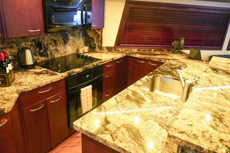 Sunset Grille Yacht Photos Pics Luxurious kitchen in 1990 Hatteras 62 Cockpit Motor Yacht with granite countertops.