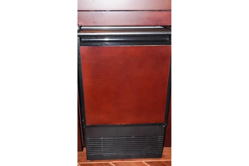 Sunset Grille Yacht Photos Pics Built-in refrigerator on 1990 Hatteras 62 Cockpit Motor Yacht, featuring wood paneling.