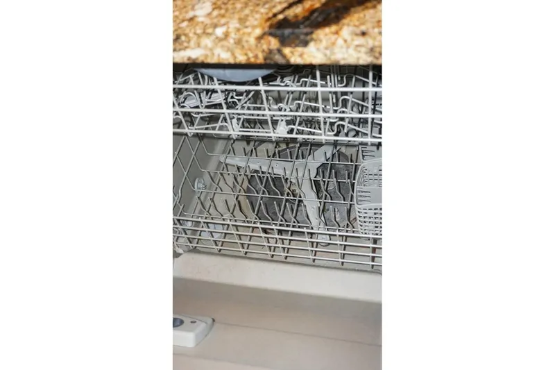 Sunset Grille Yacht Photos Pics Open dishwasher with dishes inside, granite countertop above.