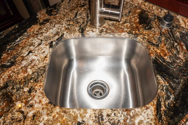 Sunset Grille Yacht Photos Pics Stainless steel sink on granite countertop in 1990 Hatteras 62 Cockpit Motor Yacht.