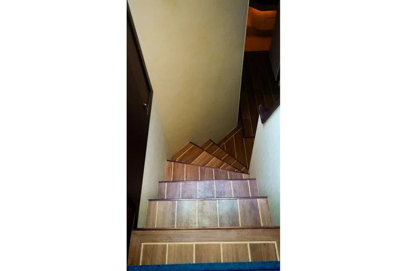 Sunset Grille Yacht Photos Pics Wooden staircase inside 1990 Hatteras 62 Cockpit Motor Yacht, leading to lower deck.