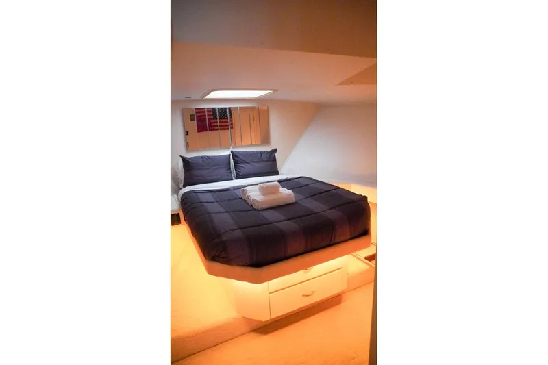 Sunset Grille Yacht Photos Pics Cozy bedroom interior of 1990 Hatteras 62 Cockpit Motor Yacht with modern bedding.