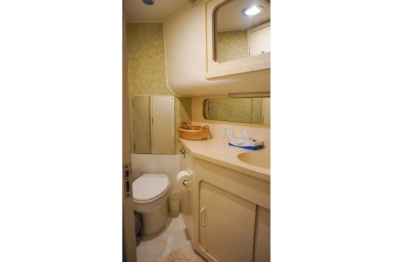 Sunset Grille Yacht Photos Pics Bathroom interior of 1990 Hatteras 62 Cockpit Motor Yacht, featuring sink and toilet.