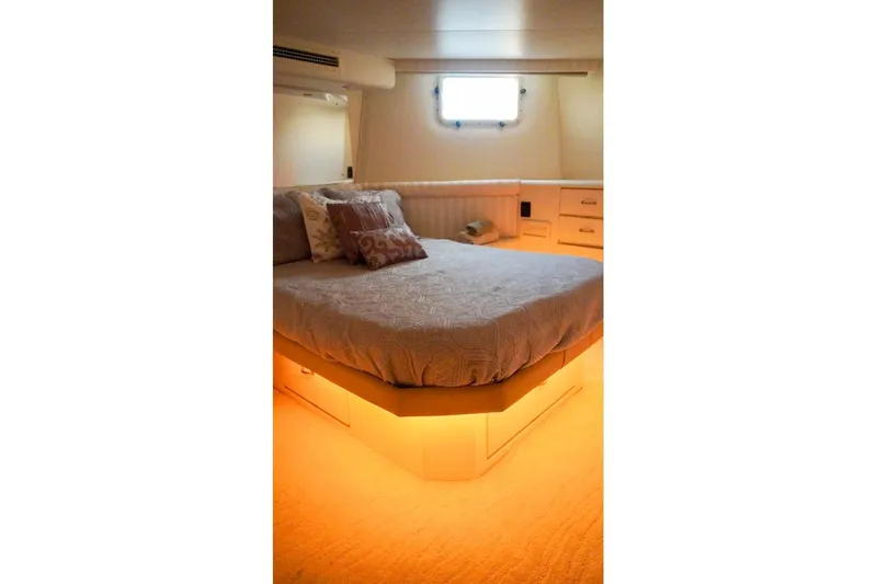 Sunset Grille Yacht Photos Pics Luxurious bedroom interior of 1990 Hatteras 62 Cockpit Motor Yacht with ambient lighting.