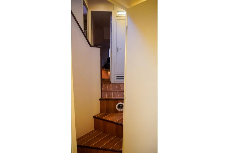 Sunset Grille Yacht Photos Pics Interior staircase of 1990 Hatteras 62 Cockpit Motor Yacht with wooden steps.