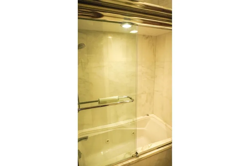 Sunset Grille Yacht Photos Pics Luxurious bathroom with glass-enclosed shower in 1990 Hatteras 62 Cockpit Motor Yacht.