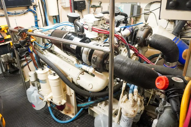 Sunset Grille Yacht Photos Pics Engine room of 1990 Hatteras 62 Cockpit Motor Yacht, showcasing complex machinery and components.