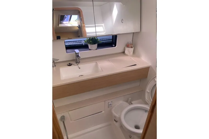 Seabreeze Smile Yacht Photos Pics Modern bathroom in 2023 Dufour 41 yacht with sink, mirror, and toilet.