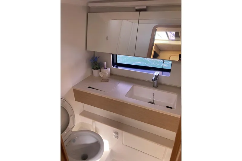 Seabreeze Smile Yacht Photos Pics Modern bathroom interior of 2023 Dufour 41 yacht with sink, mirror, and toilet.