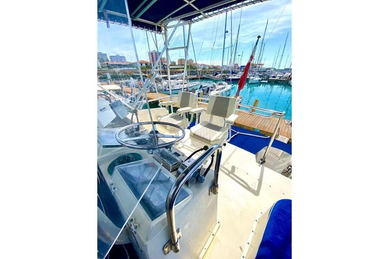  Yacht Photos Pics 1990 Hatteras 41 Convertible yacht helm with marina view, featuring steering wheel and seating.