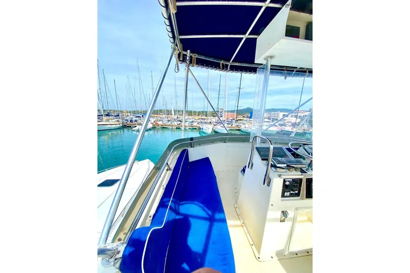  Yacht Photos Pics 1990 Hatteras 41 Convertible yacht interior with blue seating, docked in a marina.