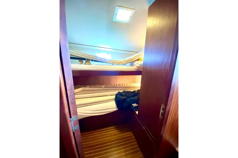  Yacht Photos Pics Interior cabin of 1990 Hatteras 41 Convertible yacht with bunk beds and wooden flooring.