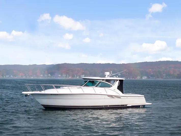  Yacht Photos Pics 2004 Tiara Yachts 3800 Open cruising on a serene lake with scenic background.