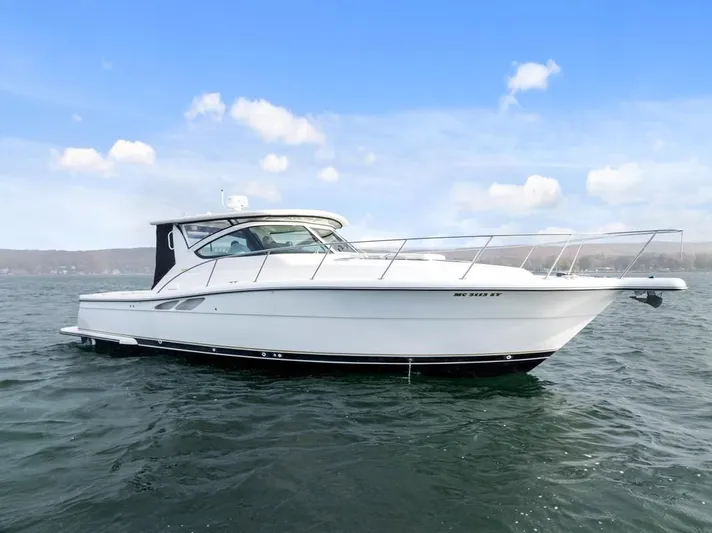  Yacht Photos Pics 2004 Tiara Yachts 3800 Open cruising on a calm lake under a clear blue sky.