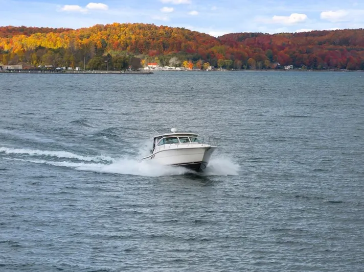 Yacht Photos Pics 2004 Tiara Yachts 3800 Open cruising on a lake with vibrant autumn foliage.