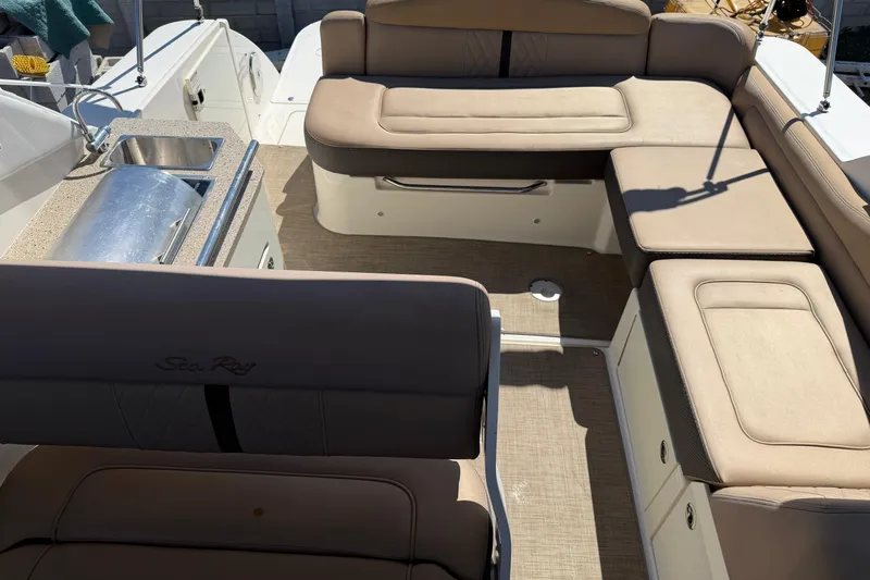  Yacht Photos Pics 2017 Sea Ray Sundancer 310 interior with beige seating and compact kitchenette.