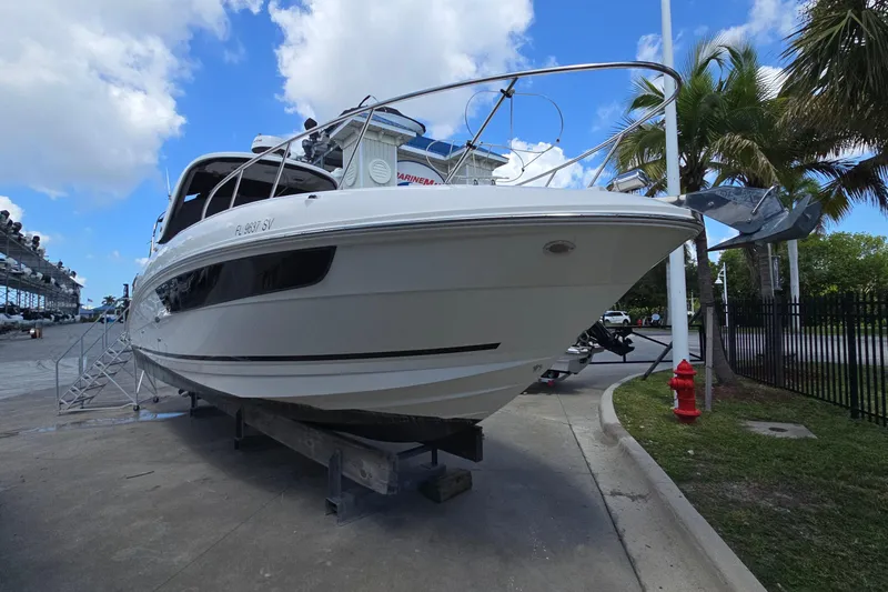  Yacht Photos Pics 2017 Sea Ray Sundancer 310 boat on dry dock, under a partly cloudy sky.