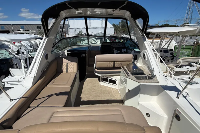  Yacht Photos Pics 2017 Sea Ray Sundancer 310 interior with seating, kitchenette, and helm under sunny skies.
