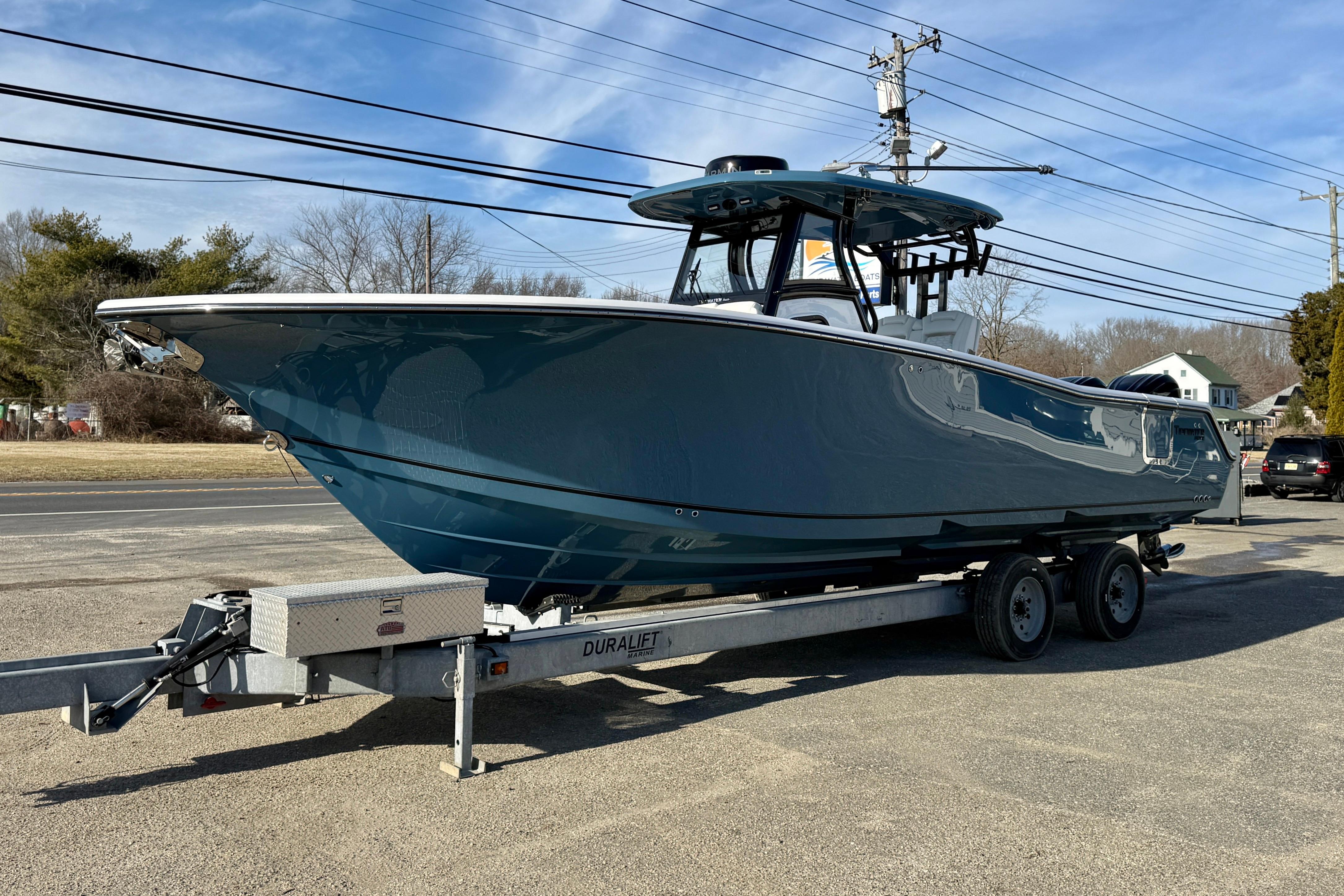 2026 Tidewater 302 CC Adventure boat on trailer, parked outdoors under clear sky.