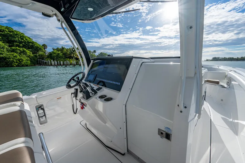  Yacht Photos Pics 2020 Edgewater 370CC boat interior with steering console, under a bright blue sky.