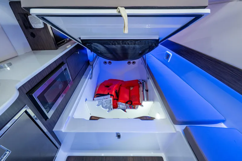  Yacht Photos Pics 2020 Edgewater 370CC cabin with storage, life jackets, and blue ambient lighting.