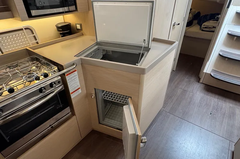 Bluebird Yacht Photos Pics Modern kitchen interior of 2022 Beneteau Oceanis 40.1 yacht with stove and fridge.
